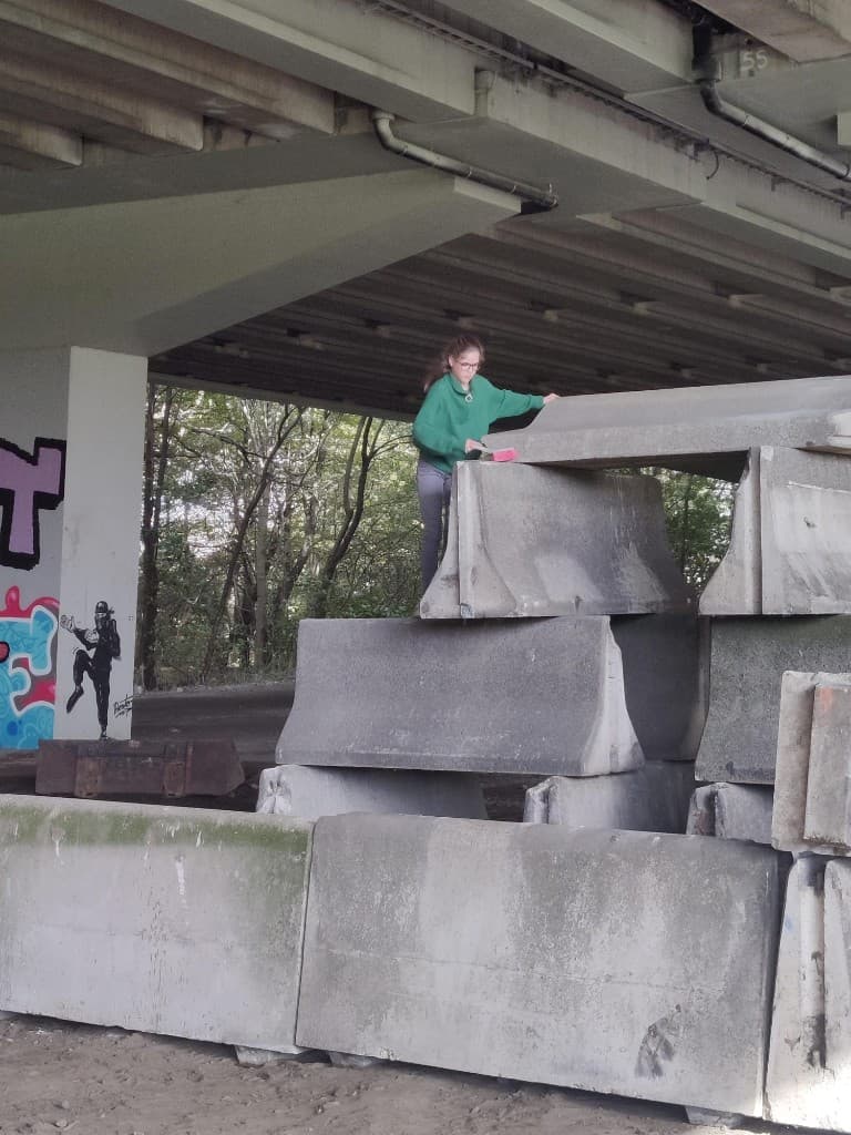 Vrijwilliger maakt betonblokken schoon onder de brug