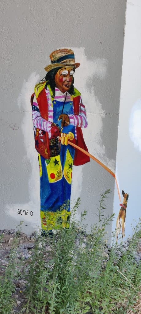 Muurschildering van een clown met hond door Sofie D.