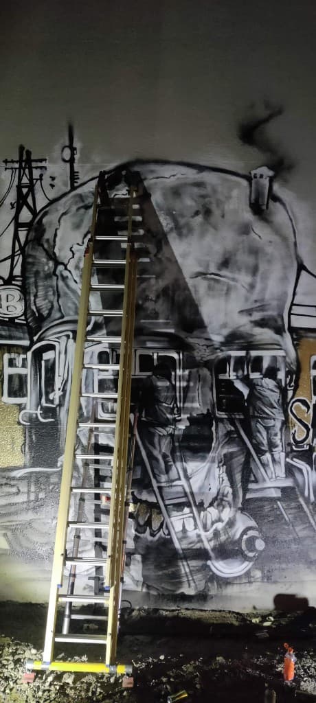 Grote schedel-graffiti bij nacht met ladder