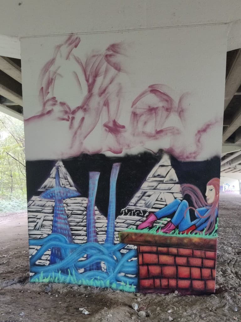 Muurschildering in avondlicht onder het viaduct