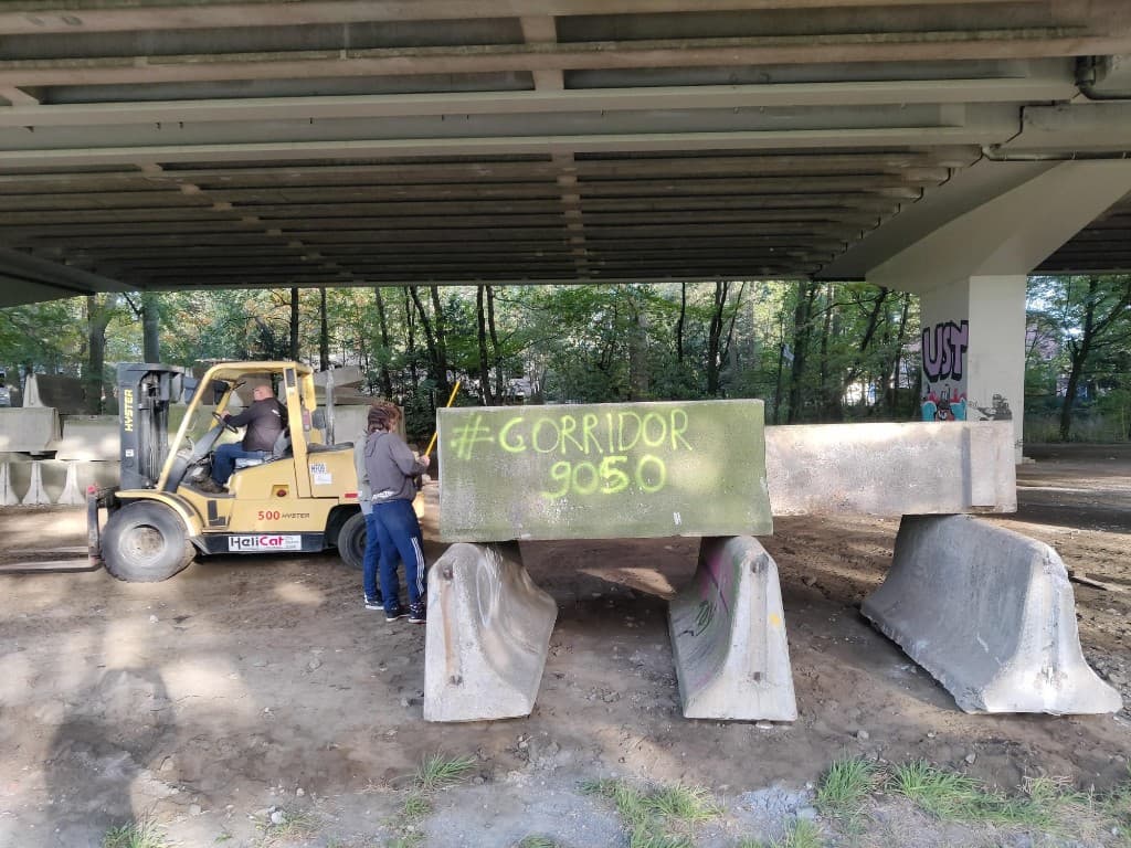 Heftruck plaatst betonblok met #CORRIDOR 9050 graffiti