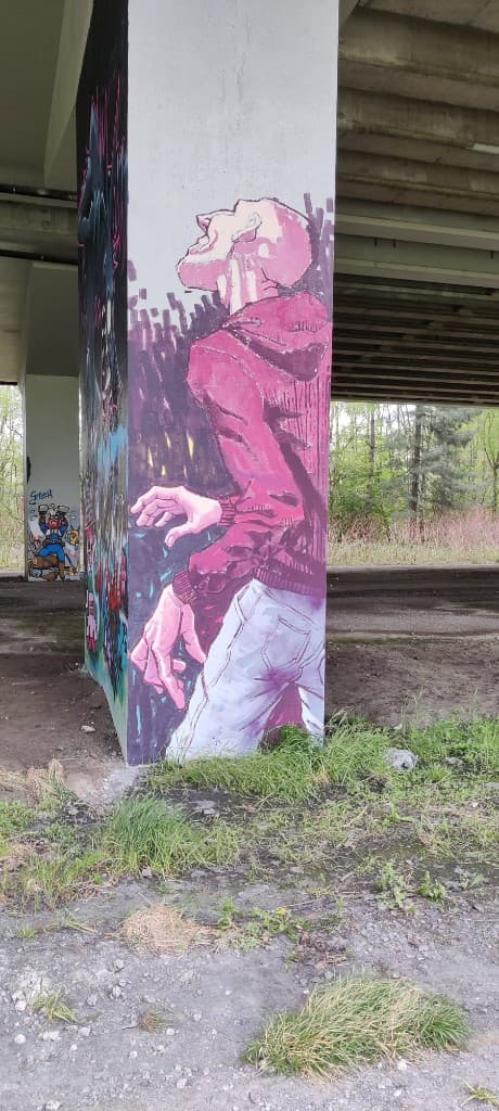 Figuur die omhoog kijkt, geschilderd op een pilaar