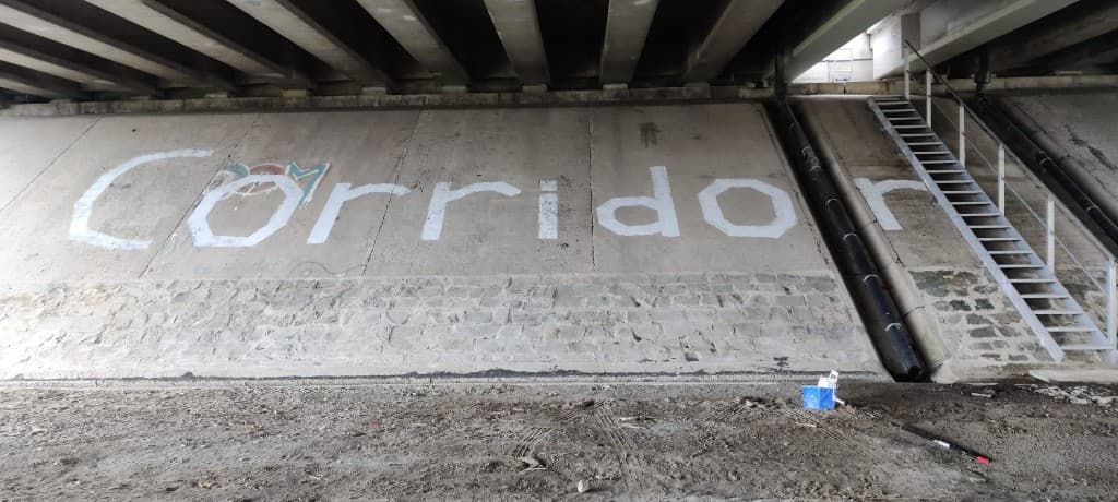 De naam Corridor geschilderd op de wand onder het viaduct